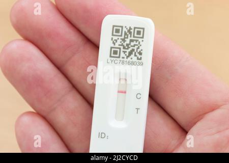 VEREINIGTES KÖNIGREICH - 26. März 2022. Mann mit einem LFT-Teststreifen mit negativem Ergebnis in der Hand, Covid-Test (COVID-19), Großbritannien Stockfoto