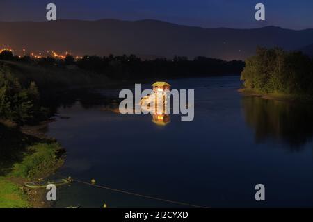 Holzhaus am Fluss bei Nacht, Serbien Stockfoto