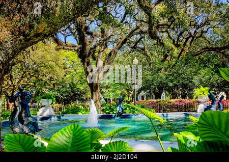 Lebende Eichen, Azaleen und andere Pflanzen umgeben den Brunnen am Washington Square, 26. März 2022, in Mobile, Alabama. Stockfoto