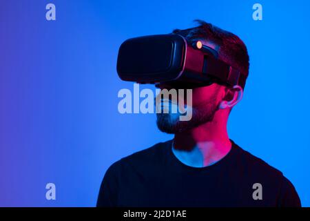 Technologie-Konzept für zukünftige Innovationen. Porträt eines jungen Mannes, der eine VR-Brille trägt und mit einem 3D-Headset die virtuelle Realität erlebt. Technologie, Wissenschaft Stockfoto