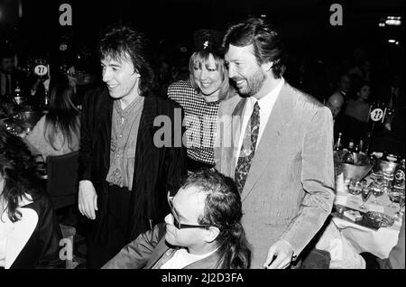 Die Ivor Novello Awards im Gorsvenor House, London. Im Bild Bill Wyman, Pattie Boyd, Eric Clapton und Elton John. 7.. April 1986. Stockfoto