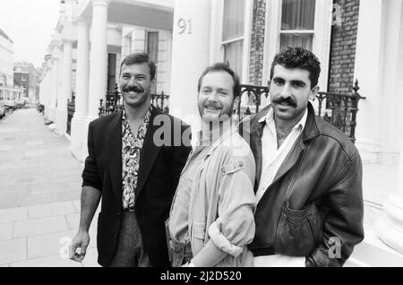 Komiker Kenny Everett vor seinem Haus in South Kensington, London, mit seinen Freunden Nikolai Grishanovich (links) und Pepe Flores (rechts) 31.. Oktober 1985. Stockfoto