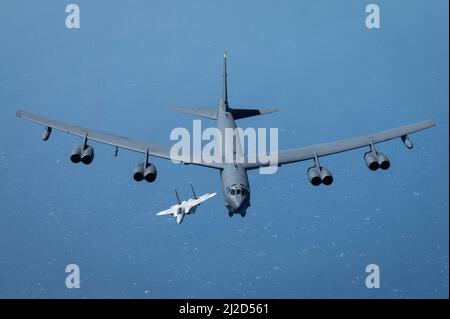 Eine Emiri Air Force F-15QA der Qatar Air Force fliegt mit einer B-52H Stratofortress der US Air Force über dem Arabischen Golf, 29. März 2022. Die Präsenz der B-52H zeigt die Fähigkeit des US Central Command, sofort Kampfflugkraft zu liefern, sowie sein Engagement für Partner und regionale Sicherheit. (USA Foto der Luftwaffe von Staff Sgt. Joseph Pick) Stockfoto