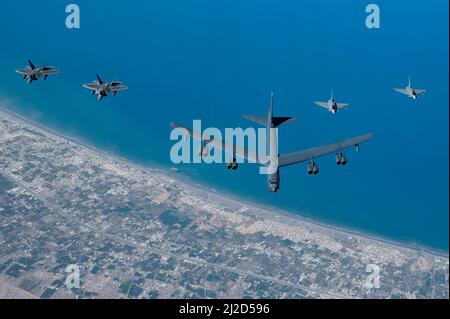 Eine US Air Force B-52H Stratofortress fliegt neben den Eurofighter-Taifunen der Royal Air Force of Oman, rechts, und den Raptoren der US Air Force F-22, links, über dem Oman, 29. März 2022. Der Flug des Bombers begann bei der Royal Air Force Fairford, England, und flog über das östliche Mittelmeer, die arabische Halbinsel und das Rote Meer, bevor er die Region abflog. (USA Foto der Luftwaffe von Staff Sgt. Jerreht Harris) Stockfoto