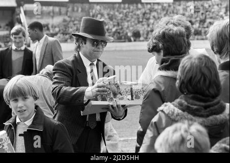 Pop Star und FC Watford Vorsitzender, Elton John, Ausgabe Ostern Eier zu Fans. Watford v Southampton Football Match. 6. April 1985. Stockfoto