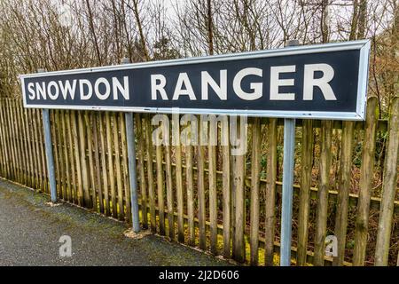 Snowdonia, Wales, UK-March 17. 2022:das Bahnsteigsschild, steht prominent an der kleinen, leeren, walisischen Bergbahnhalt, auf der Route durch Snow Stockfoto