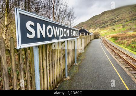 Snowdonia, Wales, UK-March 17. 2022:das Bahnsteigsschild, steht prominent an der kleinen, leeren, walisischen Bergbahnhalt, auf der Route hinauf zum Mount Stockfoto