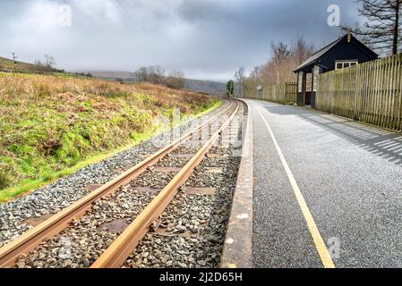 Eine kleine, schwarze Holzhütte auf der schmalen Plattform, die von Reisenden im Zug der Welsh Highland von Porthmadog nach Caernarfon, einem beliebten Rou, genutzt wird Stockfoto