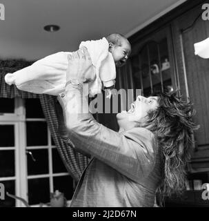 Ozzy Osbourne, ehemaliger Sänger von Black Sabbath, zu Hause zwei Wochen nach der Geburt seines Jungen Jack abgebildet.25.. November 1985. Stockfoto