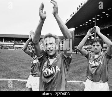 Everton holte den Ligapitel zum achten Mal in ihrer Geschichte mit einem 2-0-Sieg über die Queens Park Rangers am 6.. Mai 1985 und beendete schließlich 13 Punkte über dem zweiten Platz Liverpool. Bilder zeigen: Feiern auf dem Platz für die Everton-Spieler Kevin Sheedy, Andy Grey und Graeme Sharp, während das Team ihre Fans auf einer Ehrenrunde applaudiert. 6. Mai 1985. Stockfoto