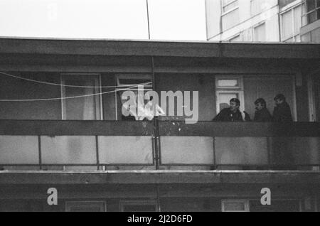 Errol Walker zwang sich am 25.. Dezember 1985 in eine Wohnung im dritten Stock des Poynter Court. Eine Frau taumelte aus und starb später an Messerstichen. Am folgenden Tag umzingelten bewaffnete Polizisten die Wohnungen, in denen Walker die vierjährige Carlene Charles als Geisel hatte, als die Belagerung fortgesetzt wurde. Ein Fenster wird zerbrochen, als die erste Betäubungsgranate in die Wohnung geworfen wird, in der Walker Charlene immer noch als Geisel hält. 26.. Dezember 1985 Stockfoto