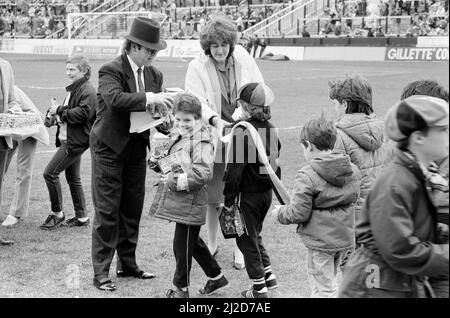 Pop Star und FC Watford Vorsitzender, Elton John, Ausgabe Ostern Eier zu Fans. Watford v Southampton Football Match. 6. April 1985. Stockfoto