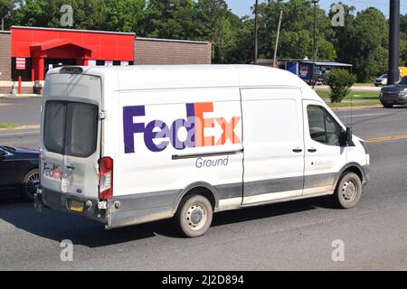 Kleiner FedEx Lieferwagen, der auf einer vierspurigen Straße in Rockport, AR, fährt; nach rechts Stockfoto