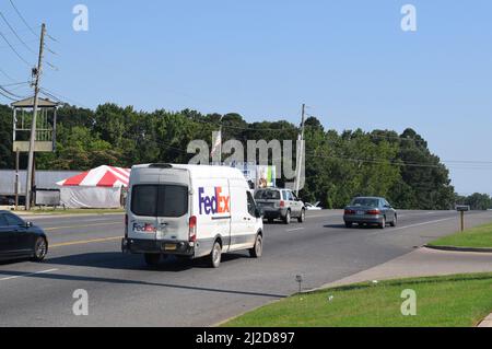 Kleiner FedEx Lieferwagen, der auf einer vierspurigen Straße in Rockport, AR, fährt; nach rechts Stockfoto