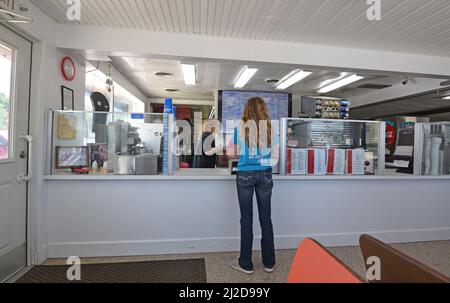 Eine junge Kundin bestellt am Schalter eines Dairy Queen Restaurants in Cissna Park, Illinois (kleine Stadt im östlichen Zentrum von Illinois) Stockfoto