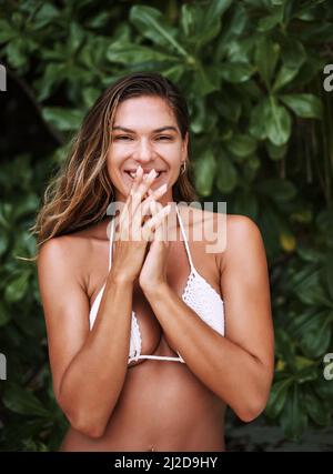 Ich bin in tropischer Stimmung. Eine kurze Aufnahme einer schönen jungen Frau, die in ihrem Bikini posiert. Stockfoto