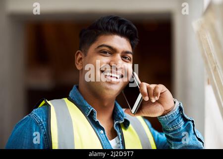 Ich kenne nur die Person, die mir bei diesem Projekt hilft. Ausgeschnittene Aufnahme eines Ingenieurs, der auf einer Baustelle auf seinem Handy sprach. Stockfoto