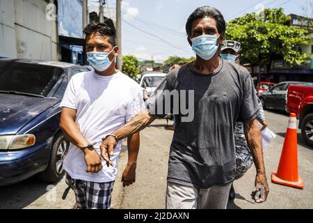 San Salvador, El Salvador. 31. März 2022. Polizeibeamte eskortieren angebliche Bandenmitglieder in ein Haftzentrum. Am Sonntag, dem 27. März, genehmigte der Kongress von Salvadorian den Ausnahmezustand, nachdem das Land seine höchste tägliche Mordrate verzeichnet hatte, mit 62 Tötungen, die aufgrund von Gewalt im Zusammenhang mit Bandenangriffen begangen wurden. Nach Angaben der salvadorianischen Regierung wurden mehr als 3.000 mutmaßliche Bandenmitglieder der Banden MS-13 und Barrio 18 festgenommen. (Foto von Camilo Freedman/SOPA Images/Sipa USA) Quelle: SIPA USA/Alamy Live News Stockfoto