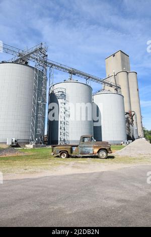 Vor den Getreideaufzügen in Hindsboro, Illinois, steht ein alter verrosteter Pick-up-Truck Stockfoto