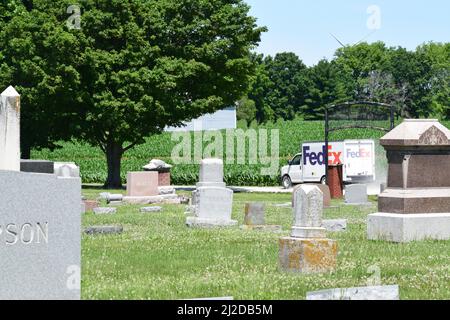 Ein kleiner FedEx-Lieferwagen auf einer Schotterstraße führt am Pleasant Ridge Cemetery im ländlichen Osten von Illinois vorbei Stockfoto