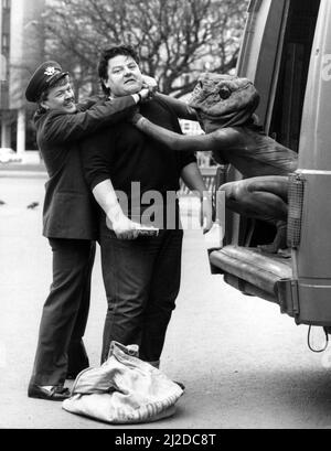 Robbie Coltrane hat gestern genug Ärger mit einem Frosch in der Kehle, ohne auch mit Postbote Stuart Noble zu kämpfen. Robbie war in George Square, Glasgow, wo er mithalf, das Mayfest in den nächsten Monaten zu fördern. Viele der Veranstaltungen werden vom Scottish Postal Board gesponsert. 11.. April 1986. Stockfoto