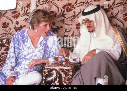 Prinz und Prinzessin von Wales, Naher Osten Tour November 1986. Unser Bild Zeigt ... Prinzessin Diana genießt am Dienstag, den 18.. November 1986, ein arabisches Frühstück mit Prinz Faisal bin Turki in einem Beduinenlager in der Region Ath Thumamah, Wüste, Saudi-Arabien. Trägt eine Tunika aus blau-weißer Seide über Seidentanzügen. Stockfoto