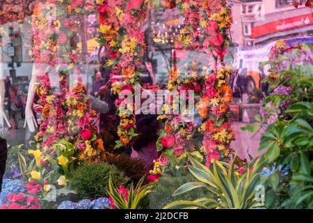 Usa. 31. März 2022. 2022 jährliche Macy's Flower Show am Herald Square. Das diesjährige Thema sind Düfte von Blumen. Die Frühjahrsshow zieht Tausende von Menschen an, von denen viele in den Laden gehen und Waren kaufen. Viele Menschen fotografieren Blumen, fotografieren Freunde und Familienmitglieder, machen Selfies und berühren sogar Blumen, um zu überprüfen, ob sie real und nicht künstlich sind. Reflexionen im Blumenfenster des Ladens. (Bild: © Lev Radin/Pacific Press via ZUMA Press Wire) Stockfoto