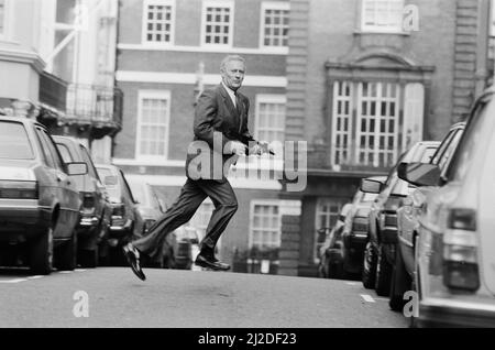 Der britische Schauspieler Edward Woodward, der in der amerikanischen Fernsehserie The Equalizer den Ex-Agenten Robert McCall spielt, posiert in London mit einem Maschinengewehr, um die Serie zu promoten. 25.. Oktober 1986. *** Lokale Bildunterschrift *** Der Equalizer Stockfoto