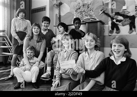 Drei Jugendliche aus Almondbury haben £80 für die Turnshaws School in Kirkburton aufgezogen. Die Mädchen (vorne, von links), Judith Midgley, Joanne Clark und Joanne Farley, überreichten den Scheck an die Cheflehrerin Miss Marilyn Simpson (zweite links) und Schüler. Die Mädchen, alle 12 Jahre alt, hielten einen Stand im Garten von Joanne Clarks Haus in Almondbury Close ab. Judiths Bruder Richard, 9, ist Schüler der Schule. Das Geld wird in einen speziellen Fonds fließen, der im nächsten Jahr Turnshaws-Schülern Aktivurlaub ermöglicht. 26.. September 1986. Stockfoto