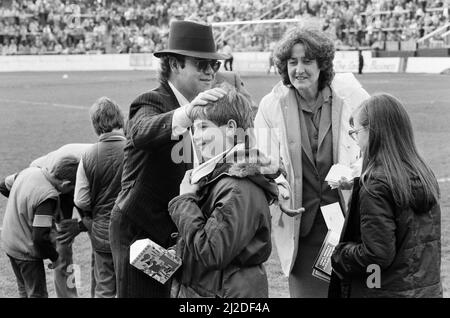 Pop Star und FC Watford Vorsitzender, Elton John, Ausgabe Ostern Eier zu Fans. Watford v Southampton Football Match. 6. April 1985. Stockfoto