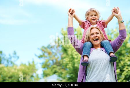 Wenn Großeltern in die Disziplin eintreten, geht sie aus. Porträt einer glücklichen Großmutter, die ihr Enkelkind auf den Schultern hält. Stockfoto