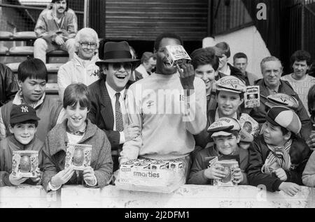 Pop Star und FC Watford Vorsitzender, Elton John, Ausgabe Ostern Eier zu Fans. Watford v Southampton Football Match. 6. April 1985. Stockfoto