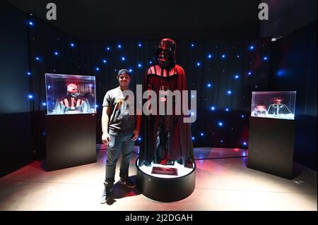 New York, USA. 31. März 2022. Jomar Crespo, 19, aus der Bronx, steht neben einer Nachbildung des Darth Vader-Kostüms bei der Fans Strike Back Exhibition, der größten Star Wars-Fanausstellung von Fans für Fans, New York, NY, 31. März 2022. Die Ausstellung enthält mehr als 600 von Fans hergestellte Objekte, Figuren, Waffen und Kostüme, die auf den 12 Star Wars-Filmen basieren; Disney kaufte Lucasfilm, den Schöpfer von Star Wars und seinen verwandten Filmen, im Jahr 2012 für mehr als $4 Milliarden. (Foto von Anthony Behar/Sipa USA) Quelle: SIPA USA/Alamy Live News Stockfoto
