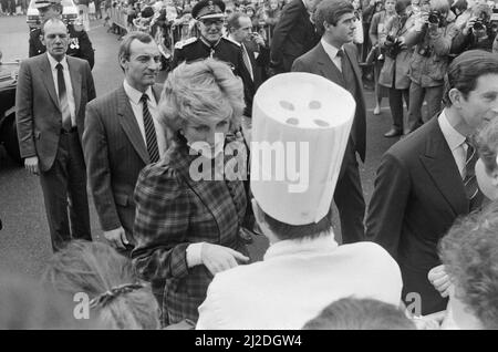 Der Prinz und die Prinzessin von Wales besuchen Mid Glamorgan in Wales, wo sie vor einer neuen Elektronikfabrik die lokalen Wohlwollen treffen. Das Bild zeigt Barry Mannakee, den Leibwächter von Prinzessin Diana, in einer schrägen gestreiften Krawatte und einer leichten Jacke mit Nadelstreifen (hinter Diana stehend). Prinzessin Diana, in der Mitte mit Tartan und ganz rechts Prinz Charles. Bild aufgenommen am 29.. Januar 1985 Stockfoto