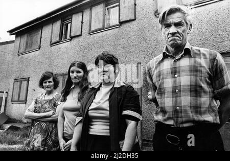 Frau Eunice Lewis, Frau Janet Lewis, Frau Barbara Lewis und Herr John Lewis, die in einem Haus für Obdachlose leben, das als Strafe Block beschrieben wird, auf dem Gurnos Estate. Zwei Familien besetzen das Haus und teilen sich ein Bad und eine Küche. 26.. Juni 1986. Stockfoto