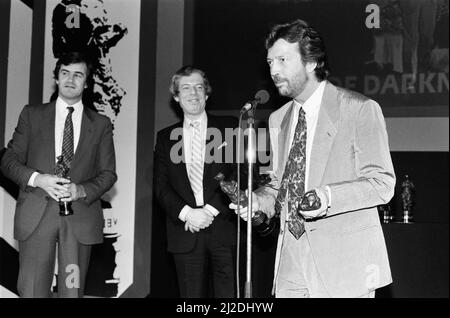 Die Ivor Novello Awards im Gorsvenor House, London. Im Bild Eric Clapton, der auf der Bühne einen Preis für seine Titelmelodie zum TV-Thriller Edge of Darkness gewonnen hat. 7.. April 1986. Stockfoto