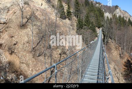 Lange Hängebrücke aus Edelstahl ohne Menschen in den Bergen in Italien Stockfoto