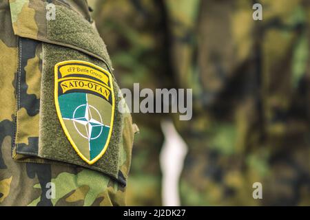 Flagge und Symbol der NATO auf einer Soldatenuniform, NATO-Einheit zur Integration von Truppen, Nahaufnahme Stockfoto