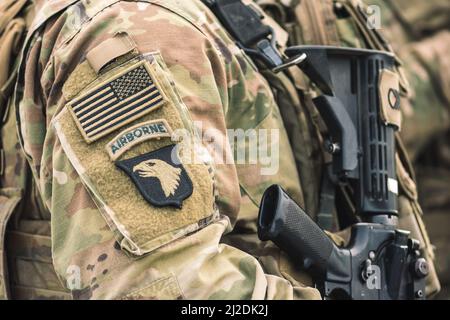 Flagge der Vereinigten Staaten und Symbol des Airborne United States Marine Corps auf einer Soldatenuniform mit Schusswaffe oder Gewehr, NATO Force Integration Unit Stockfoto