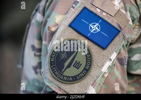 Flagge und Symbol der NATO, Organisation des Nordatlantikvertrags auf einer Soldatenuniform, NATO-Einheit zur Truppenintegration in Litauen, baltische Staaten, Nahaufnahme Stockfoto