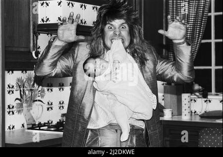 Ozzy Osbourne, ehemaliger Sänger von Black Sabbath, zu Hause zwei Wochen nach der Geburt seines Jungen Jack abgebildet.25.. November 1985. Stockfoto