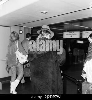 Der Popstar Elton John zeigte auf dem Bild seinen Pony-Schwanz, als er von Los Angeles aus am Londoner Flughafen Heathrow ankommt. 17.. Oktober 1986. Stockfoto