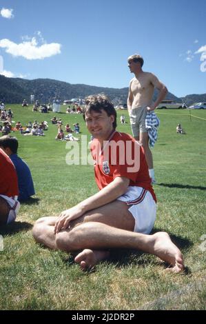 Die englische Fußballmannschaft nimmt an einem Warm-Up-Spiel gegen ein Team der US-Luftwaffe in Colorado Springs, USA, Teil, um sich auf das Weltcup-Turnier 1986 in Mexiko vorzubereiten. England gewann das Spiel 11-0. Der englische Fußballspieler Bryan Robson entspannt sich beim Betrachten der Action. 11. Mai 1986. Stockfoto