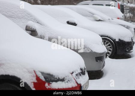 Wernigerode, Deutschland. 01. April 2022. Verschneite Fahrzeuge, die im Stadtgebiet abgestellt werden. Glatte Straßen haben am Morgen zu Verkehrsbehinderungen geführt. Bis in die Tiefebene gibt es in der Region Schnee. Weitere Schneeschauer werden in den kommenden Tagen erwartet. Quelle: Matthias Bein/dpa/Alamy Live News Stockfoto