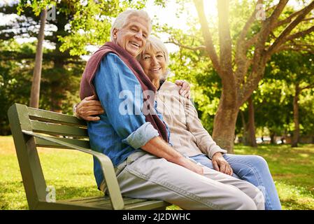 Sie machten ihre, eine glückliche Ehe. Porträt eines glücklichen älteren Paares, das auf einer Parkbank sitzt. Stockfoto