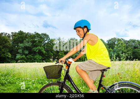 Motion-Foto des Jungen Fahrrad fahren in einem Feld Stockfoto