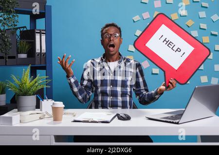 Erschrocken schreienden Geschäftsmann Hodling Pappe Blase Schild um Hilfe von Mitarbeitern wegen der Gefahr. Schockiert und ängstlich rief ein junger erwachsener Unternehmer am Schreibtisch um Hilfe. Stockfoto
