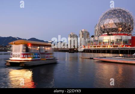 Die Aquabus-Passagierfähre fährt in der Abenddämmerung auf dem False Creek in Vancouver in Richtung Telus World of Science. Stockfoto