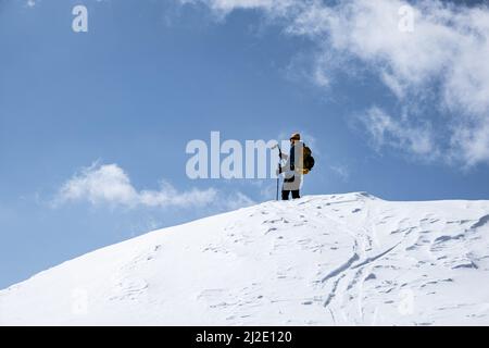 Skibergsteiger, der die Spitze eines Berges in der Schweiz erreicht Stockfoto