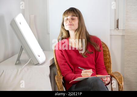Frau Lichttherapie Tagebuch Stockfoto